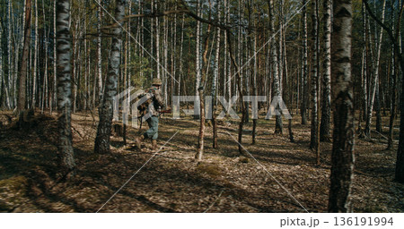 German soldier walking with backpack in birch forest during WWII reenactment 136191994