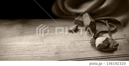 An antique leather sling lies on wooden desk An antique leather sling lies on wooden desk 136192320