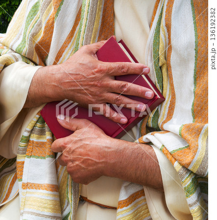 Old man holding red book 136192382