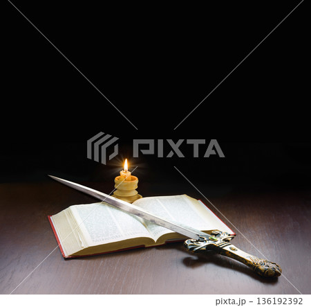 Old book and sword on the table 136192392