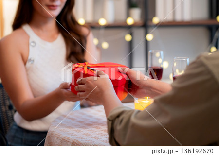 Romantic asian man giving heart shape gift box to girlfriend, surprise for Valentine's Day. Romantic asian man giving heart shape gift box to girlfriend, surprise for Valentine's Day. 136192670