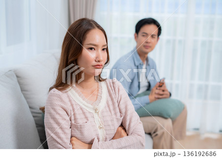 Angry asian couple sitting sofa with conflict and frustrated, woman ignoring boyfriend. 136192686