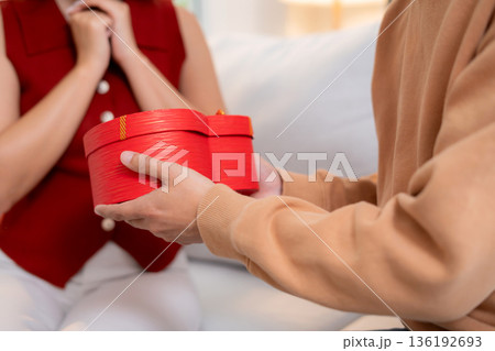 Happy asian man giving heart gift box to girlfriend celebrating Valentine's Day or anniversary. Happy asian man giving heart gift box to girlfriend celebrating Valentine's Day or anniversary. 136192693