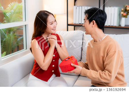 Happy asian man giving heart gift box to girlfriend celebrating Valentine's Day or anniversary. Happy asian man giving heart gift box to girlfriend celebrating Valentine's Day or anniversary. 136192694