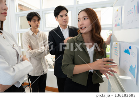 Leader asian business woman presenting financial report statistic to colleague. 136192695