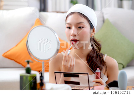 Beauty happy young asian woman applying makeup with lipstick looking mirror. 136192712