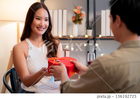 Romantic asian man giving heart shape gift box to girlfriend, surprise for Valentine's Day. Romantic asian man giving heart shape gift box to girlfriend, surprise for Valentine's Day. 136192725