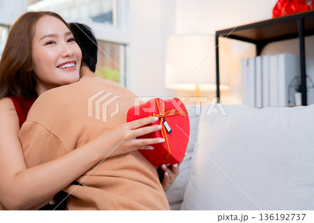 Happy asian couple embracing with love after receiving heart gift box. 136192737