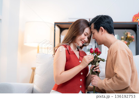 Happy asian woman receiving rose bouquet from boyfriend with celebrating Valentine's Day. Happy asian woman receiving rose bouquet from boyfriend with celebrating Valentine's Day. 136192753