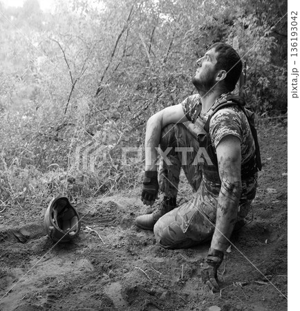 Young soldier sitting on the ground 136193042