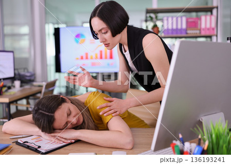 Stressful conversation unfolds in a modern office as one colleague supports another during a heavy workload and emotional moment 136193241