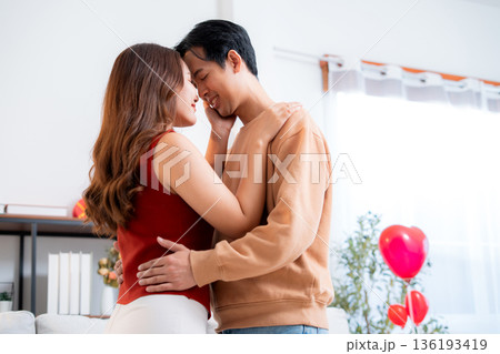 Romantic asian couple standing with head touch, feeling love and tenderness at home. 136193419