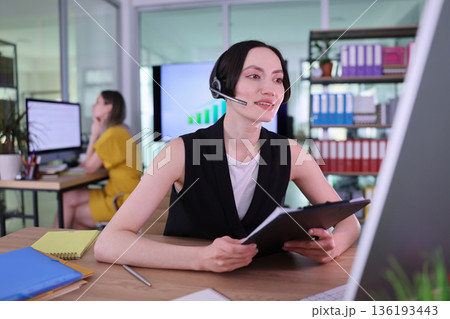 Engaging in an important business conversation while efficiently managing tasks in a modern office setting 136193443