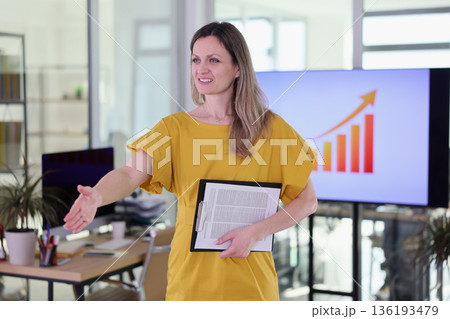 Confident businesswoman engaging with team members in a bright, modern office space during a productive meeting Confident businesswoman engaging with team members in a bright, modern office space during a productive meeting 136193479