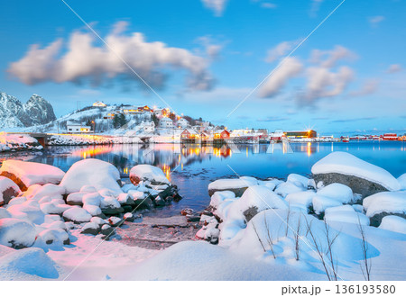Outstanding evening cityscape of Reine town. Red rorbuers on the shoore of Reinefjorden. 136193580