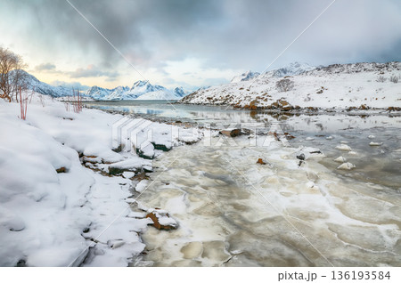 Outstanding morning view of Torsfjorden fjord with cracked ice and snowy mountain peaks at background. 136193584