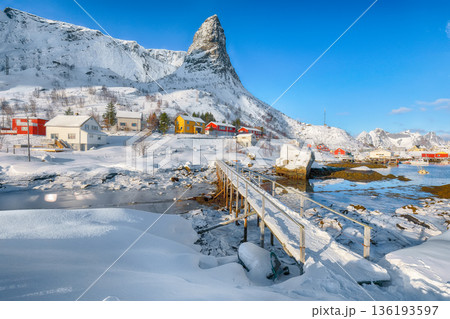 Outstanding winter sunny view on Hammarskaftet Mountain Peak with footbridge above Gravdalbukta bay . Outstanding winter sunny view on Hammarskaftet Mountain Peak with footbridge above Gravdalbukta bay . 136193597