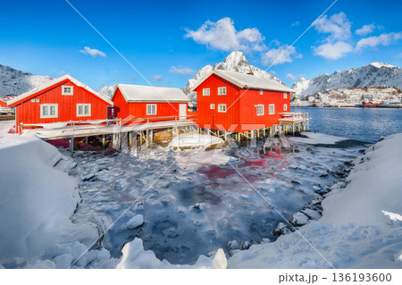 Outstanding winter sunny view on Reine Village and Gravdalbukta bay with cracked ice. Outstanding winter sunny view on Reine Village and Gravdalbukta bay with cracked ice. 136193600
