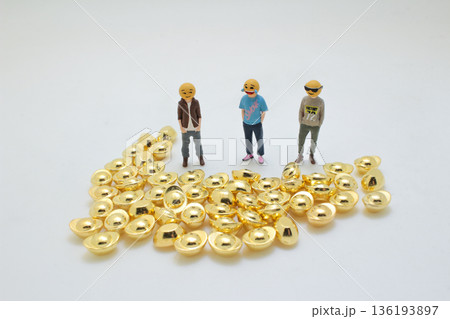 Miniature Figures Standing Calmly Beside Shiny Gold Ingots Miniature Figures Standing Calmly Beside Shiny Gold Ingots 136193897