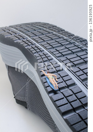 Miniature Surfer Riding Wave Shaped By Giant Shoe Miniature Surfer Riding Wave Shaped By Giant Shoe 136193925