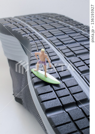 Miniature Surfer Balancing Confidently On Giant Shoe Tread Miniature Surfer Balancing Confidently On Giant Shoe Tread 136193927