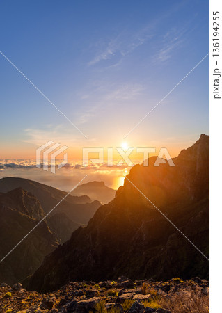Vertical composition sunrise at Pico do Arieiro Madeira with glowing sun over ocean clouds sea 136194255