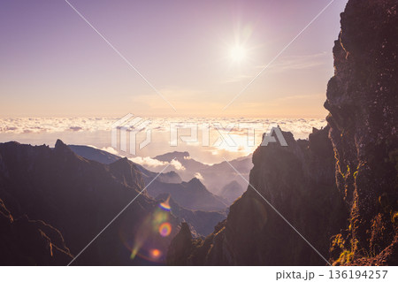 Rocky ledge viewpoint at Pico do Arieiro shows hikers over cloud ocean at sunrise Madeira view Rocky ledge viewpoint at Pico do Arieiro shows hikers over cloud ocean at sunrise Madeira view 136194257