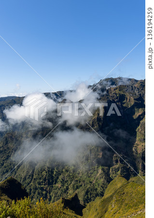 Pico Ruivo ridgeline above Curral das Freiras as white clouds drift through steep volcanic valleys Pico Ruivo ridgeline above Curral das Freiras as white clouds drift through steep volcanic valleys 136194259