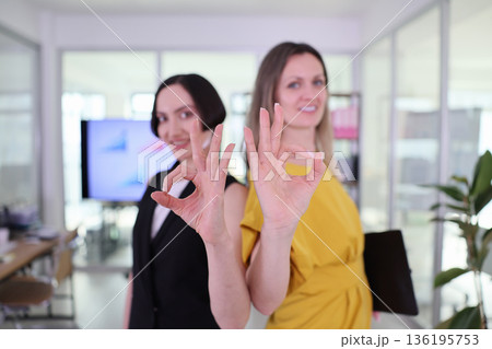 Two confident women showcase teamwork and success in a bright modern office setting while sharing a moment of joy together Two confident women showcase teamwork and success in a bright modern office setting while sharing a moment of joy together 136195753