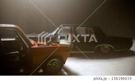 Miniature red and black toy cars in smoke 136196014