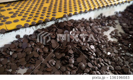 Chocolate chips accumulating from industrial conveyor belt Chocolate chips accumulating from industrial conveyor belt 136196083