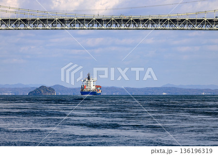 A large ocean liner departed, passing under Kanmon bridge toward the sea at Kitakyushu, Japan. A large ocean liner departed, passing under Kanmon bridge toward the sea at Kitakyushu, Japan. 136196319