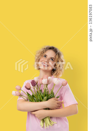 A woman holds flowers and smiles for the holiday 136197083