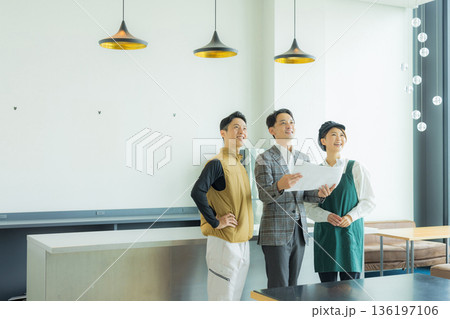 資料を見ながら打ち合わせする空調服の職人の男性 136197106