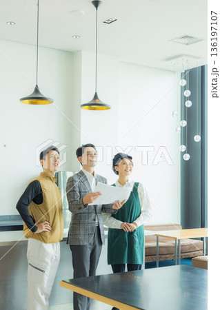 資料を見ながら打ち合わせする空調服の職人の男性 136197107