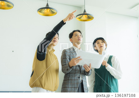 資料を見ながら打ち合わせする空調服の職人の男性 136197108