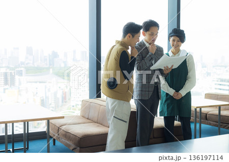 資料を見ながら打ち合わせする空調服の職人の男性 136197114