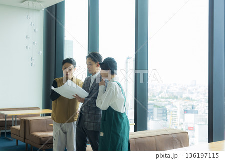 資料を見ながら打ち合わせする空調服の職人の男性 136197115