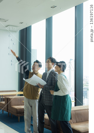 資料を見ながら打ち合わせする空調服の職人の男性 136197116