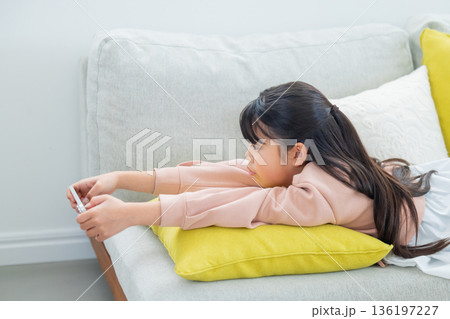 スマホで遊ぶ小学生の女の子　 136197227
