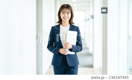 オフィスでノートパソコンを持つ笑顔のビジネスウーマン 日本人 女性 スーツ 働くイメージ 採用 会社 オフィスでノートパソコンを持つ笑顔のビジネスウーマン 日本人 女性 スーツ 働くイメージ 採用 会社 136197493