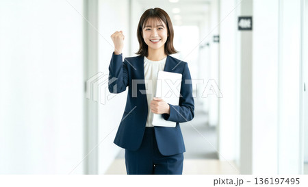 ガッツポーズをする笑顔のビジネスウーマン ノートパソコンを持つ 仕事 成功 やる気 イメージ 素材 136197495