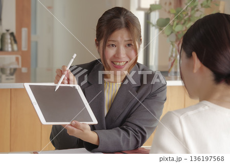 FPの女性が保険や資産運用の説明をする様子 136197568