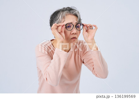 視力の低下に困るシニア女性 視力の低下に困るシニア女性 136199569
