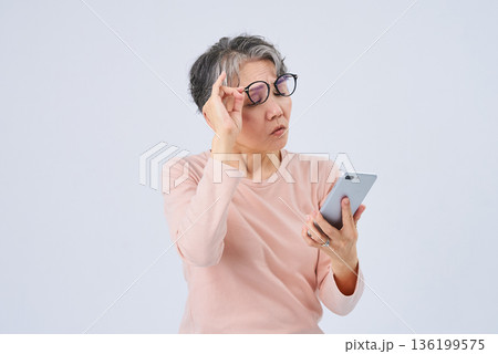 視力の低下に困るシニア女性 136199575