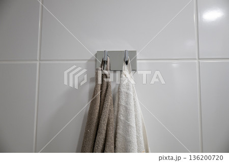 Minimal bathroom towels hanging on wall hook in modern interior 136200720