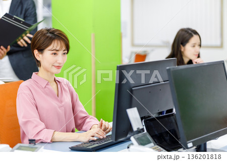 オフィスでデスクワークをする女性社員 オフィスでデスクワークをする女性社員 136201818