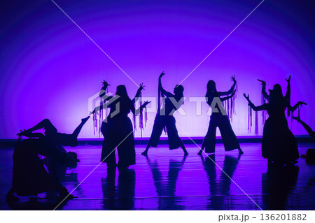 Dancers performing expressive choreography with dramatic purple lighting Dancers performing expressive choreography with dramatic purple lighting 136201882