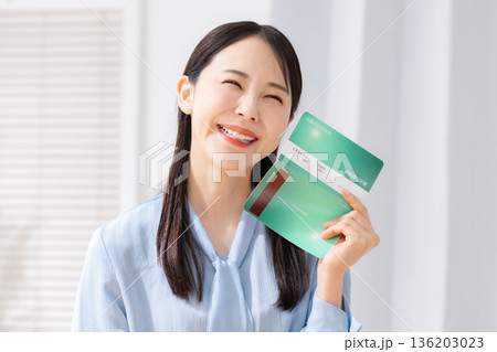 通帳を見て喜ぶ女性 通帳を見て喜ぶ女性 136203023