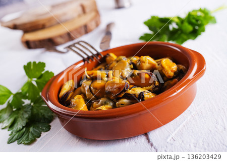 Mussels with sauce in a dish on a light background. 136203429